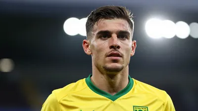 A photorealistic image of an anonymous Norwich City player in their yellow and green kit, with a sharp focus on the eyes...