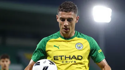 A tight action crop of an anonymous young Norwich City player in a Carrow Road training session, wearing a green and...