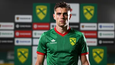 A tight, waist-up shot of a ruggedly-built, 25-year-old, former Norwich City midfielder with a determined expression...